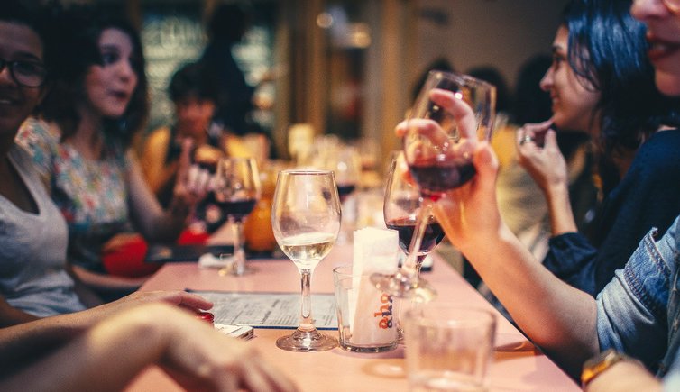 people drinking liquor and talking on dining table close up