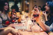 people drinking liquor and talking on dining table close up