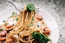 selective focus photography of pasta with tomato and basil