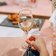 person holding wine glass near clear shot glasses