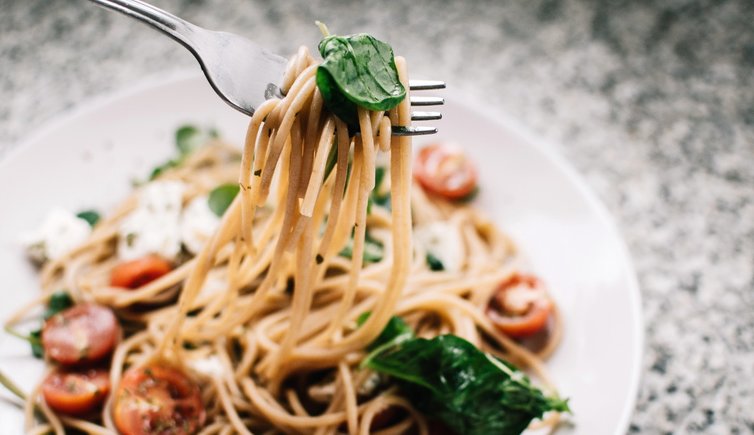 selective focus photography of pasta with tomato and basil